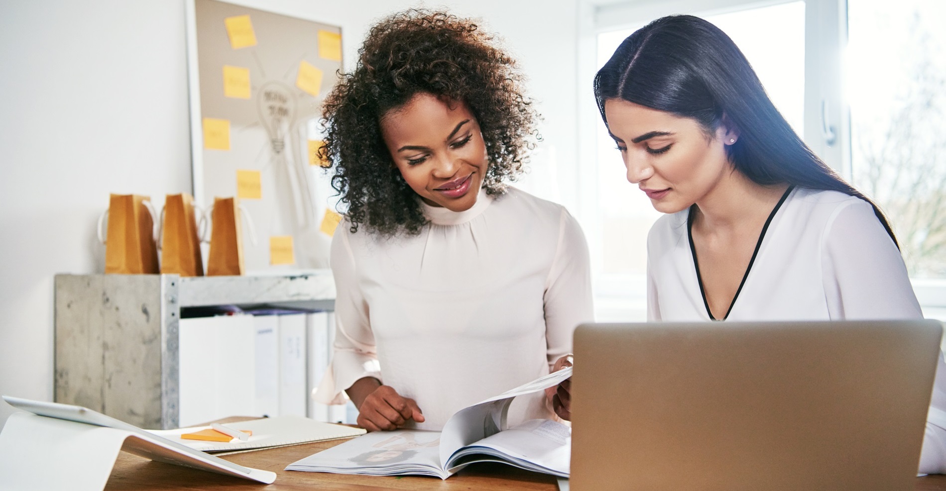 Two,Young,Attractive,Female,Business,Partners,Working,On,Paperwork,Paging